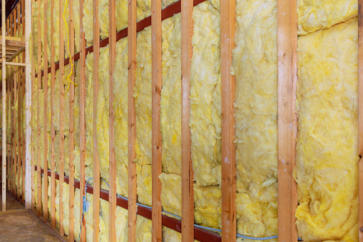 Adding thermal insulation to a wall using mineral rock wool during new construction