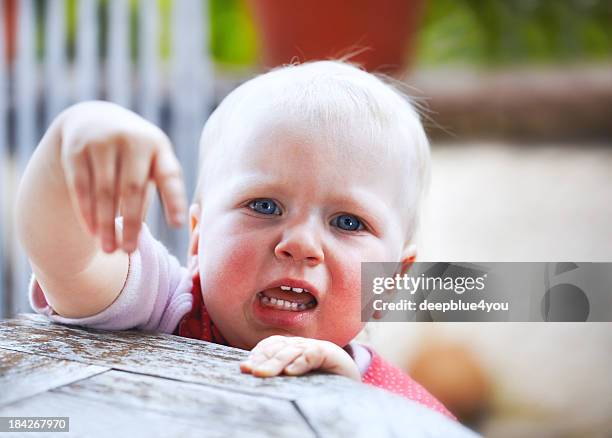 crying little child standing on table pointing with finger - baby hands pointing stock pictures, royalty-free photos & images