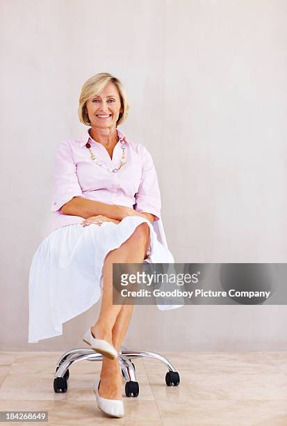 pretty senior woman relaxing in chair - legs crossed at knee stock pictures, royalty-free photos & images