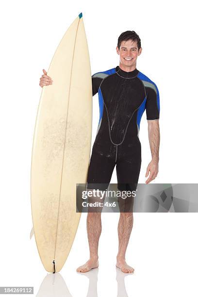 man standing with a surfboard - surfer wetsuit stockfoto's en -beelden