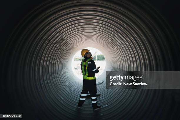 engineers inspecting circular water pipe construction for water, oil, natural gas, and fuel transport pipelines. - piper stock pictures, royalty-free photos & images