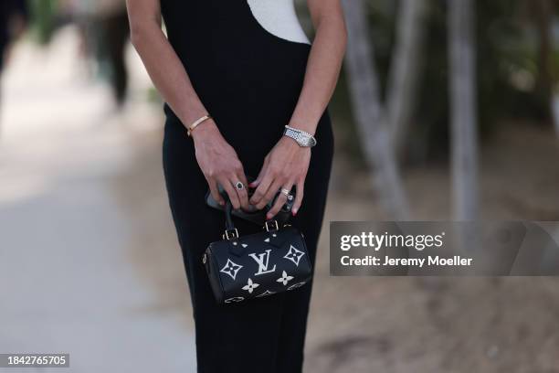 Kimberly Jones seen wearing black / white hands pattern knit sleeveless long dress, Cartier Panthère silver / gold bi-color watch, Louis Vuitton...