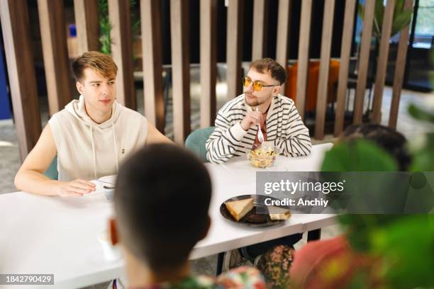 kollegen, die in ihrer cafeteria zu mittag essen - office snack stock-fotos und bilder