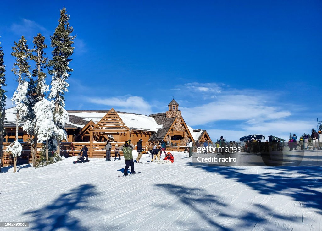 People outside the on mountain Sunspot lodge at Winter Park ski resort, Colorado.