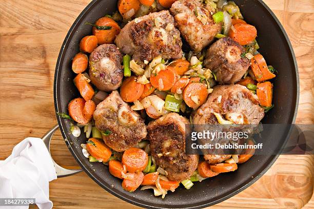 browning oxtails and vegetables for soup - an ox stockfoto's en -beelden