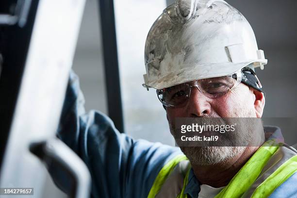arbeiter in schutzhelm und sicherheit gläser - bauarbeiter helm stock-fotos und bilder