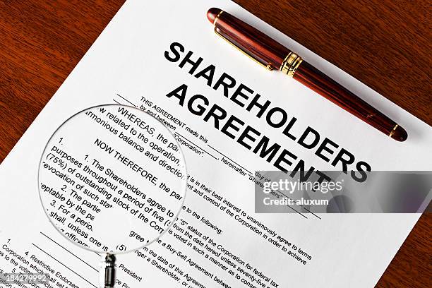 magnifying glass on shareholders agreement - aktieägare bildbanksfoton och bilder