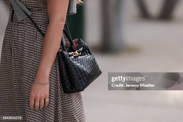 Julia Fayzi seen wearing brown checked flattered long dress and Bottega Veneta black leather crossbody bag, on December 08, 2023 in Miami, Florida.