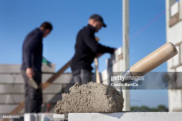 construction d'une maison. maçon de travail. - truelle photos et images de collection