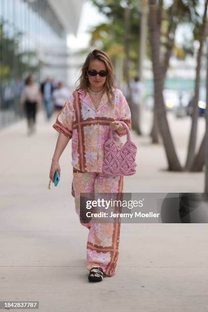 Anna Sophie seen wearing Le Specs brown oval sunglasses, gold earrings and necklace, pearl necklace, pink colorful floral print pattern shirt /...