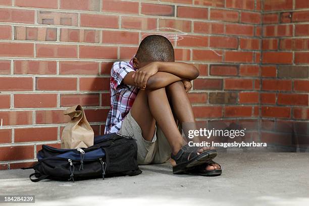 sitting alone a poor child is bullied at school. - defeat fear stock pictures, royalty-free photos & images