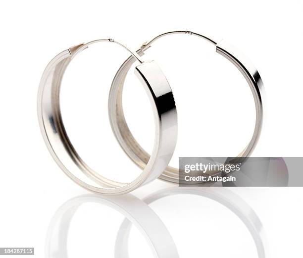 silver hoop earrings on a white background - earring stock pictures, royalty-free photos & images