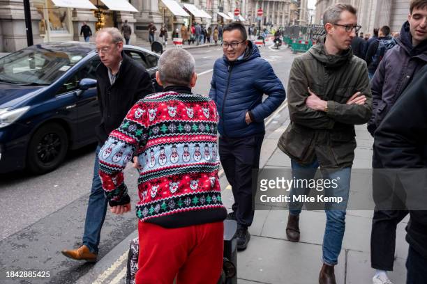 Man wearing a Christmas jumper interacting with passers by on 7th December 2023 in London, United Kingdom. Once an item of riducule, the Chritmas...