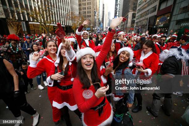 People dressed in Santa Claus costumes participate in the annual SantaCon bar crawl on December 09, 2023 in New York City.