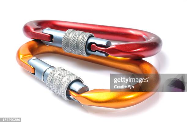 vermelho e laranja mosquetão - equipamento de alpinismo imagens e fotografias de stock