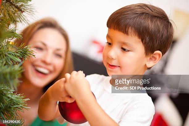 young boy shaking present on christmas morning - shaking hangs stock pictures, royalty-free photos & images