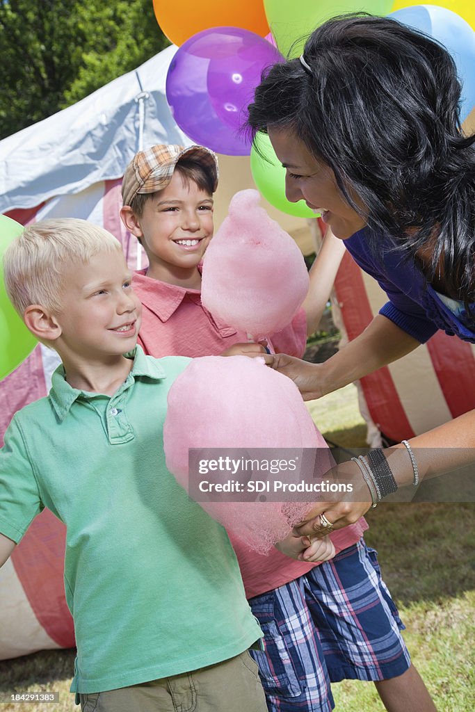 Young Boys Receiving Cotton Candy From Mom at Carnival