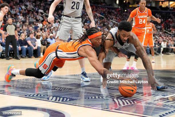 Maliq Brown of the Syracuse Orange and Dontrez Styles of the Georgetown Hoyas fight for a loose ball in the second half during a college basketball...