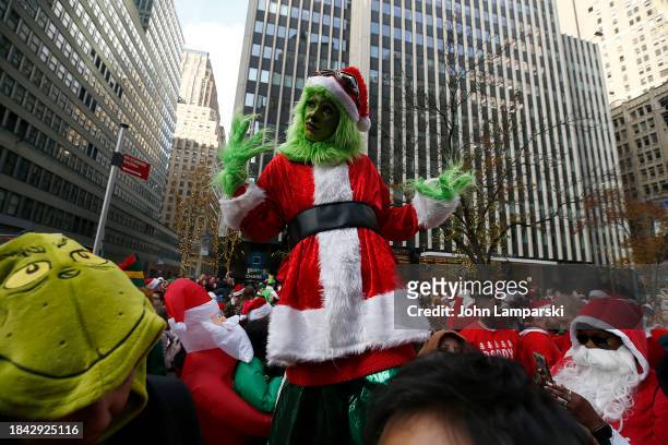 Person dressed in a Grinch costume participates in the annual SantaCon bar crawl on December 09, 2023 in New York City.
