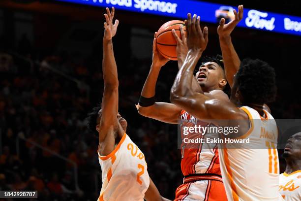 Terrence Shannon Jr. #0 of the Illinois Fighting Illini gets fouled on his way to the basket against Jordan Gainey and Tobe Awaka of the Tennessee...