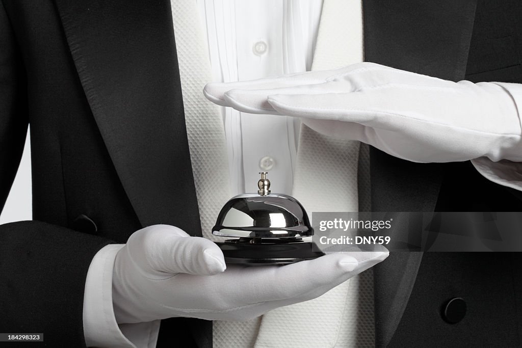 Butler holding and about to ring a service bell