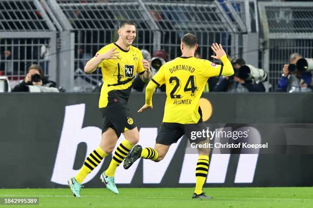 Niklas Suele of Borussia Dortmund celebrates with teammate Thomas Meunier after scoring their team's first goal during the Bundesliga match between...