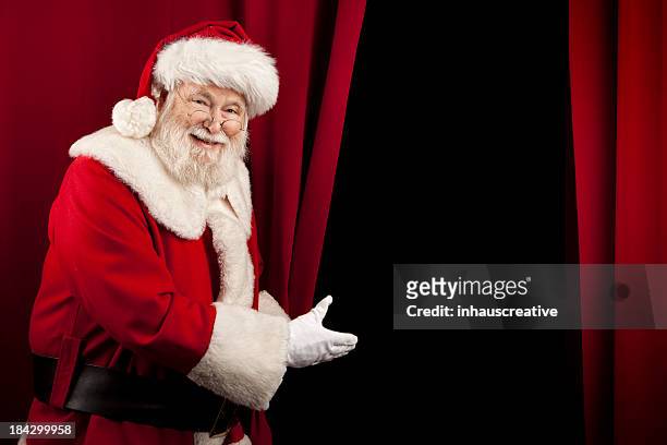 pictures of real santa claus showing you behind the curtain - inviting gesture stock pictures, royalty-free photos & images