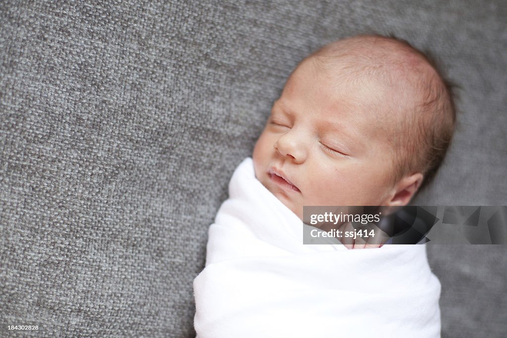 Newborn Baby Swaddled While on Gray Blanket