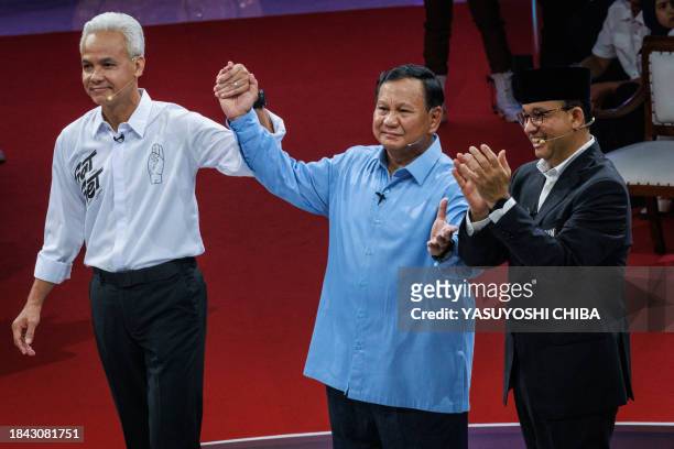 Three presidential candidates, Anies Baswedan , Prabowo Subianto and Ganjar Pranowo pose after the first presidential election debate at the General...