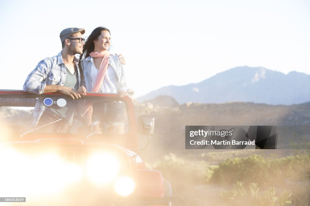 Couple standing in sport utility vehicle