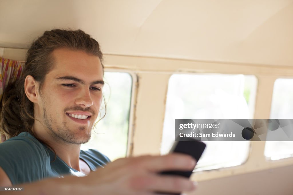 Homem usando telefone celular em caravanas de van
