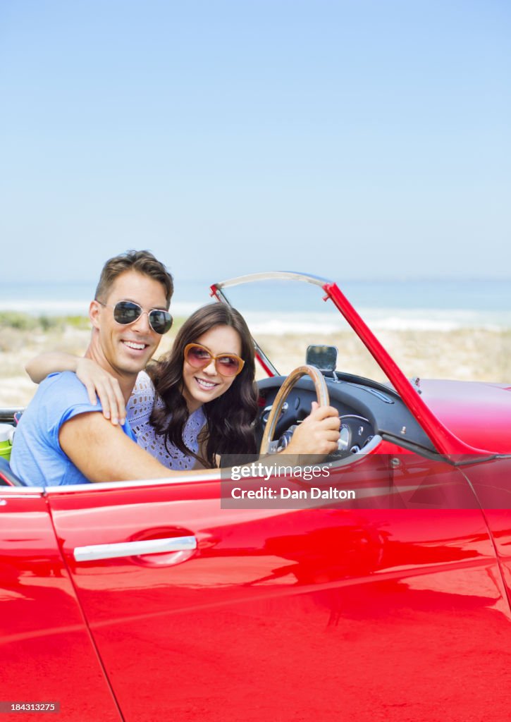 Conducción convertible en la playa en pareja