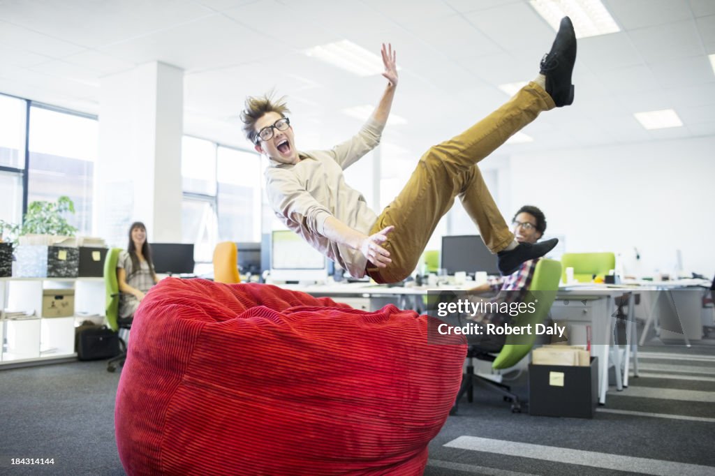 Empresario saltar en beanbag silla de oficina
