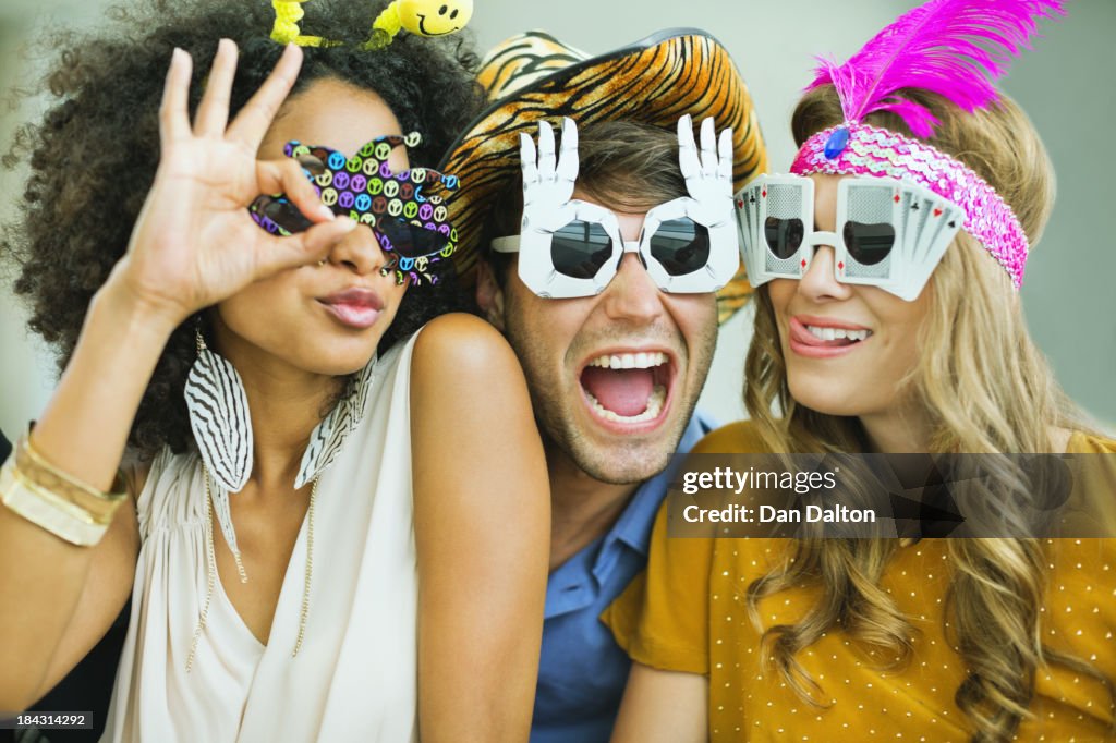 Smiling friends wearing decorative glasses