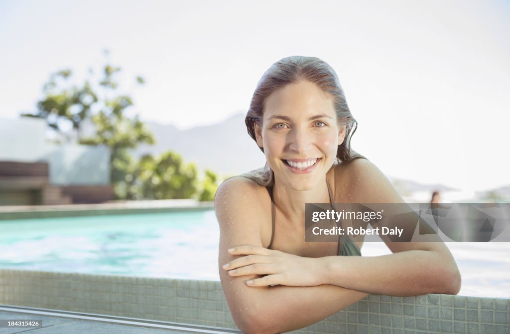 Porträt eines lächelnden Frau am Rande des Swimmingpools