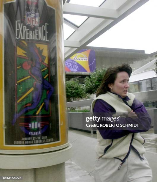 An unidentified woman entering the NFL Experience protects herself from the weather after an ice storm in the Atlanta area early 29 January 2000. The...