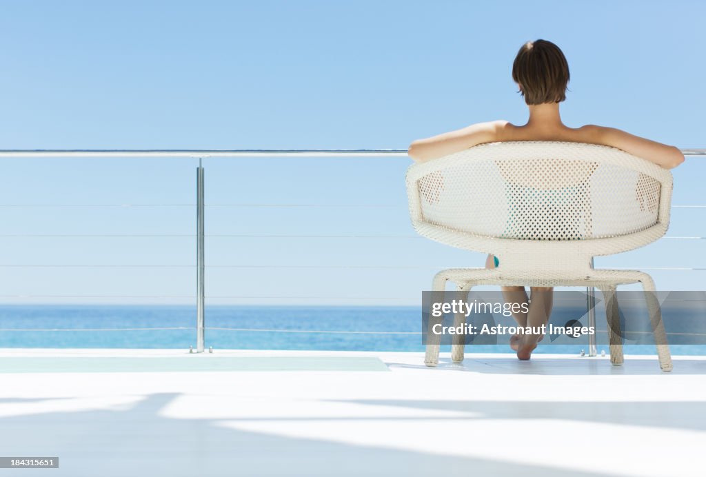 Mujer en sillón mirando a vista al mar
