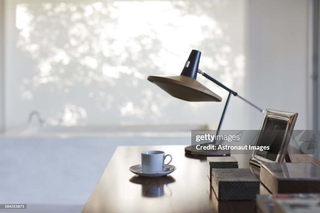 Tazza di caffè e lampada sulla scrivania in ufficio