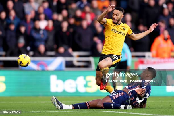 Matheus Cunha of Wolverhampton Wanderers is challenged by Willy Boly of Nottingham Forest during the Premier League match between Wolverhampton...