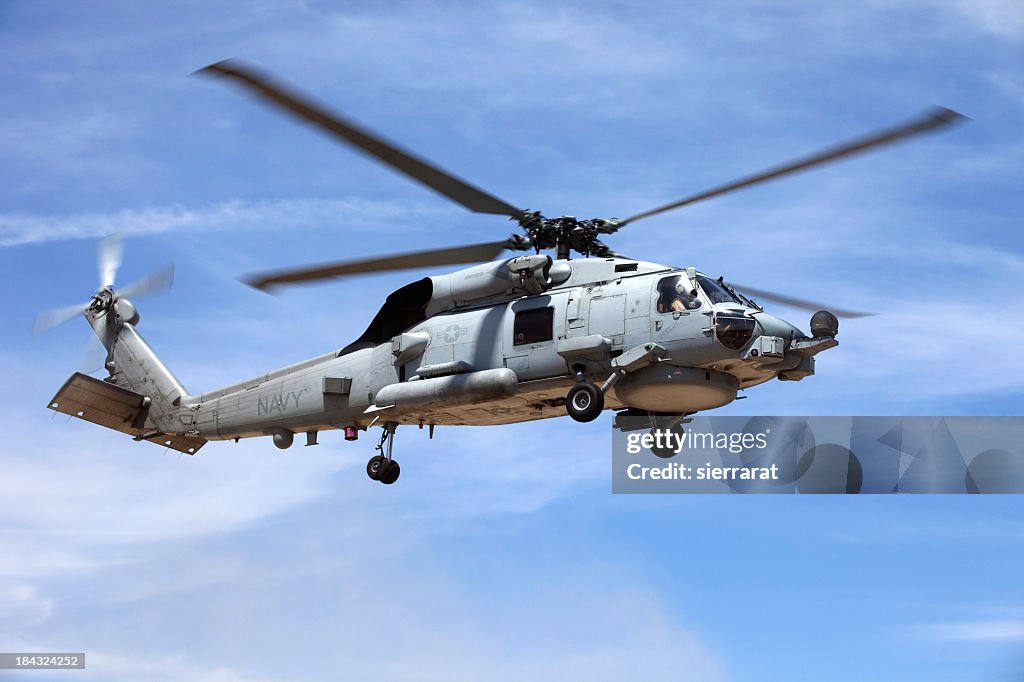Looking up at a Seahawk helicopter flying in blue sky