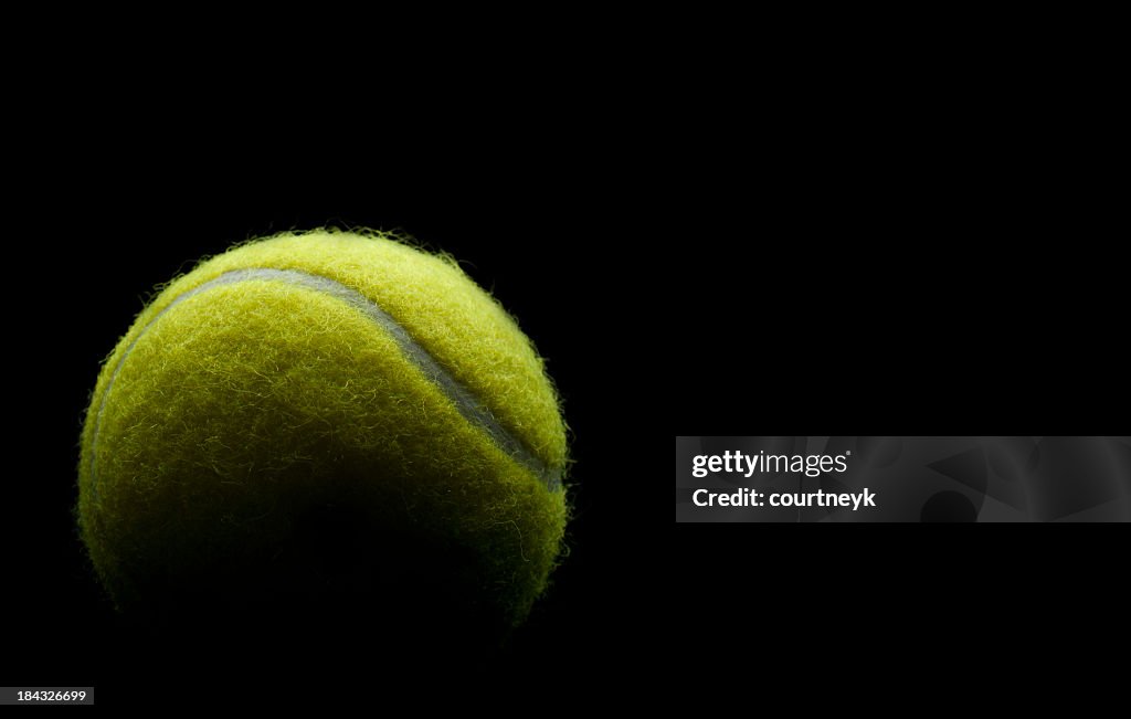 Bola de tenis sobre un fondo negro.