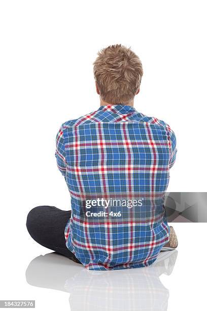 vista posterior de un hombre ubicación en el piso - sitting on floor fotografías e imágenes de stock