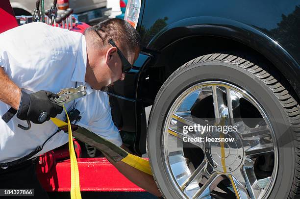 tow truck driver strapping a vehicle for towing - roadside assistance stock pictures, royalty-free photos & images