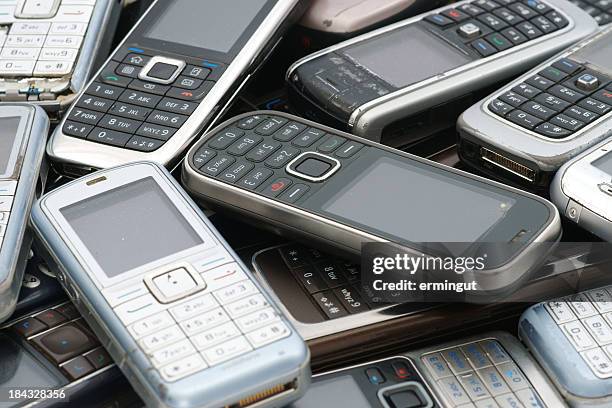 antiguo utilizado cellphones pila como fondo - former fotografías e imágenes de stock