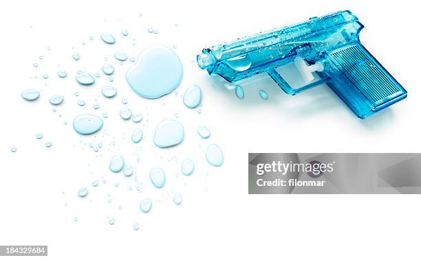 blue squirt gun next to blue drops of water - waterpistool stockfoto's en -beelden