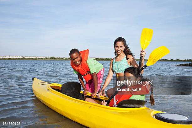 adolescente aider les enfants en kayak - girl rowing boat photos et images de collection