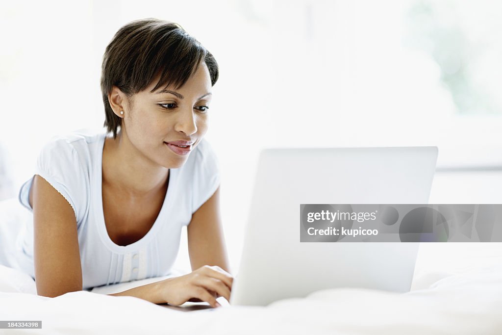 Pretty woman using laptop in bed