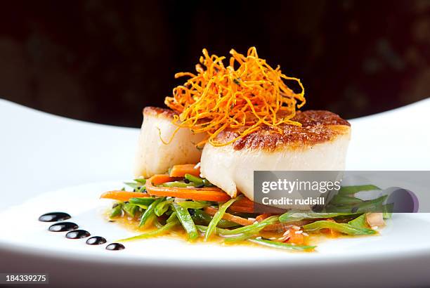 close-up of cooked scallops on bed of vegetables - franse gerechten stockfoto's en -beelden