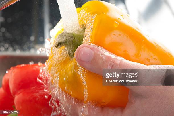 peppers being washed - food waste stockfoto's en -beelden