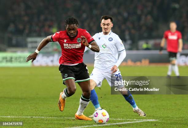 Derrick Koehn of Hannover 96 runs with the ball whilst under pressure from Paul Nebel of Karlsruher SC during the Second Bundesliga match between...